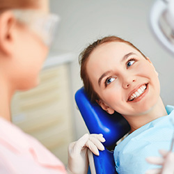 Young woman smiling in dnetal chair