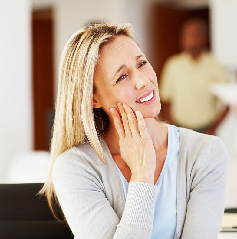 Woman in pain holding cheek