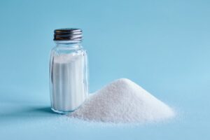 Salt shaker next to a pile of salt