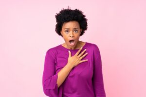 Woman shocked while holding her hand to her chest